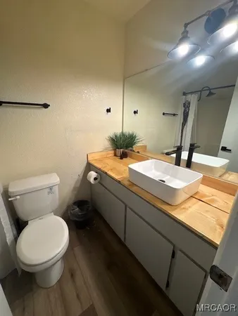 a bathroom with a granite countertop toilet sink and mirror