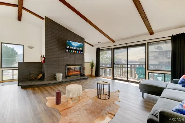a living room with furniture a fireplace and a floor to ceiling window