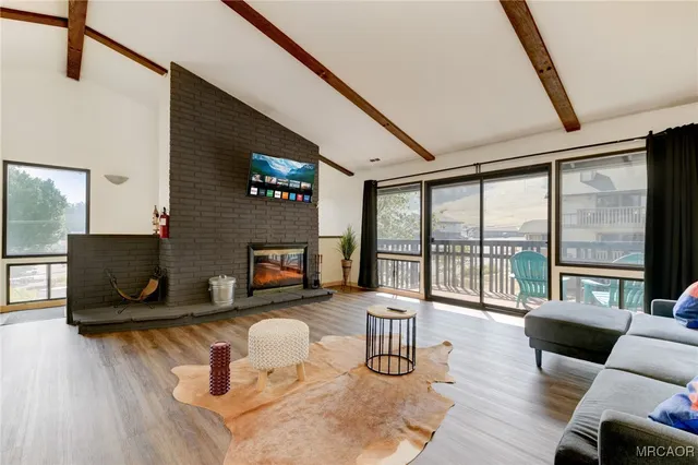 a living room with furniture a fireplace and a floor to ceiling window