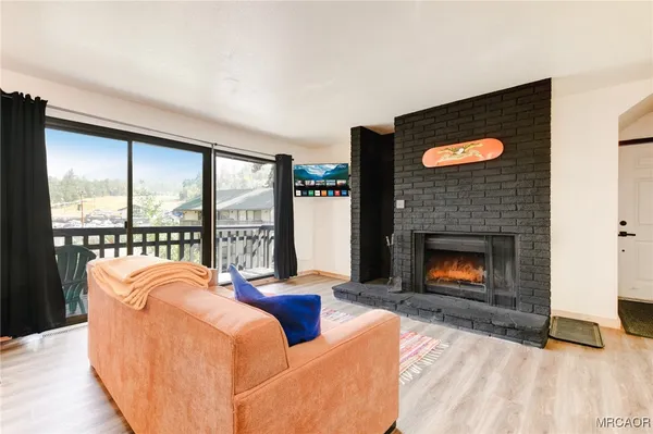 a living room with couch a fireplace and a flat screen tv