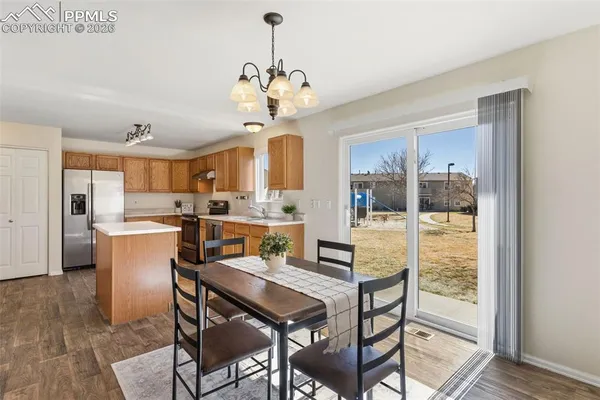 a dining room filled chandelier and wooden floor