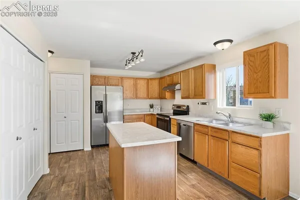a kitchen with a sink a counter top space stainless steel appliances and cabinets