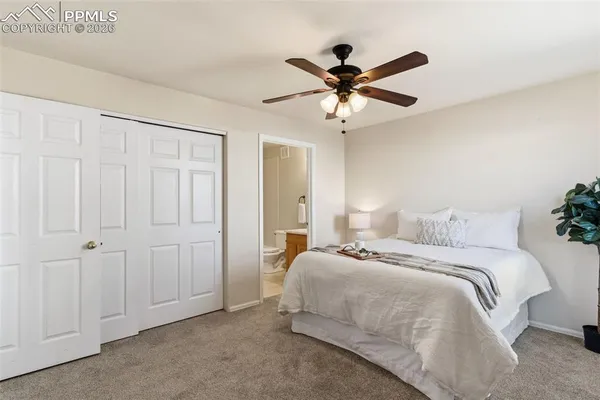 a bedroom with a bed and a ceiling fan