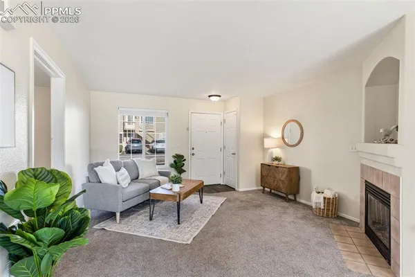 a living room with furniture a fireplace and a large window