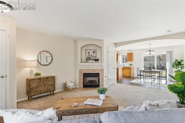 a living room with furniture a fireplace and a table