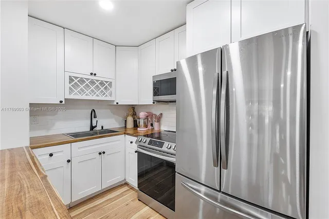 a kitchen with stainless steel appliances a refrigerator sink and cabinets