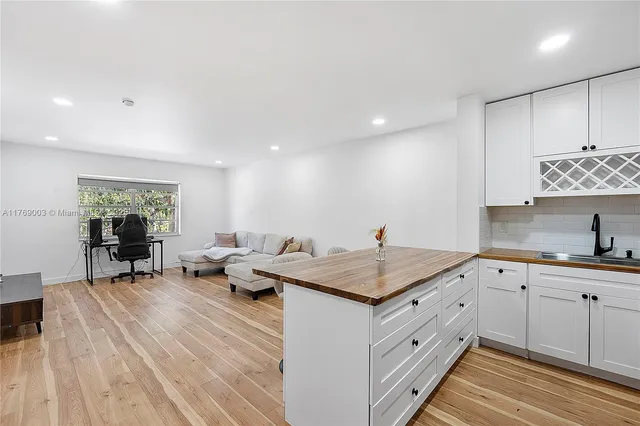 a kitchen that has a sink and a stove with wooden floor