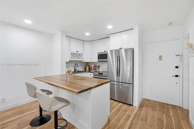 a kitchen with kitchen island a sink appliances and cabinets