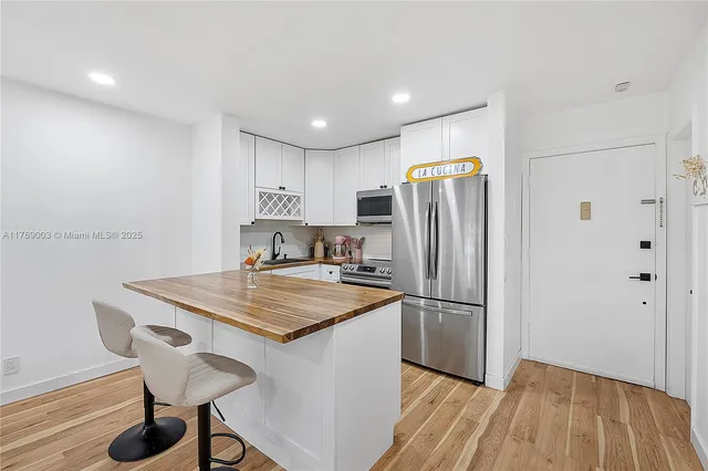a kitchen with refrigerator cabinets and wooden floor