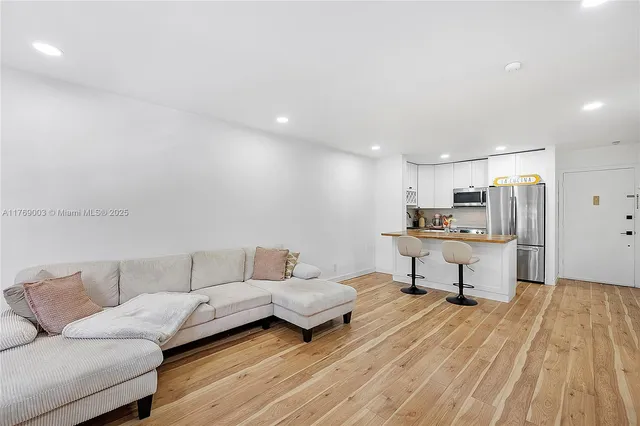a living room with furniture and view of kitchen