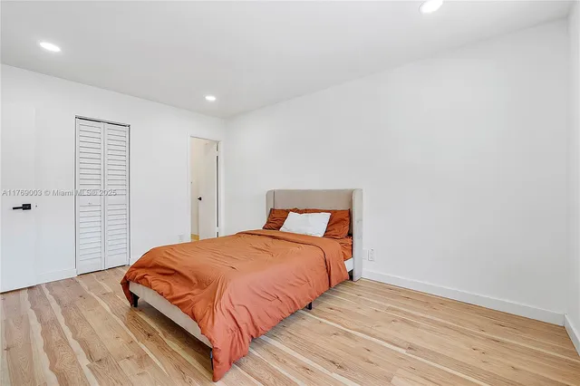 a bedroom with a bed and wooden floor