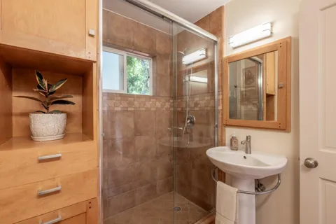 a bathroom with a sink a mirror and a shower