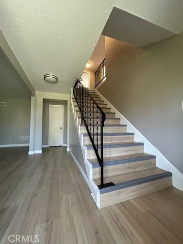 a view of a livingroom with wooden floor and staircase
