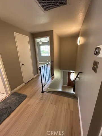 an empty room with wooden floor and a ceiling fan