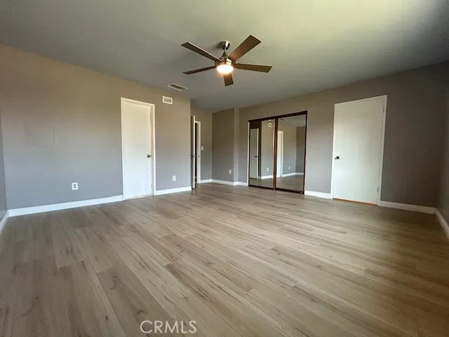 a view of a living room with stainless steel appliances wooden floor and a fireplace
