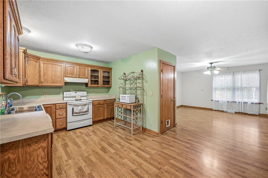 3451 East State Road Jamestown, PA 16134 - Photo 11 of 49 a large kitchen with a wooden floor and cabinets