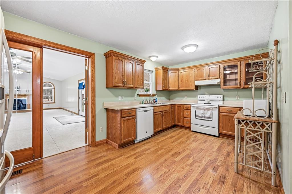3451 East State Road Jamestown, PA 16134 - Photo 12 of 49 a kitchen with stainless steel appliances kitchen island granite countertop a stove a sink and a refrigerator with wooden floor
