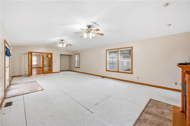 a view of a room with a ceiling fan and hardwood floor