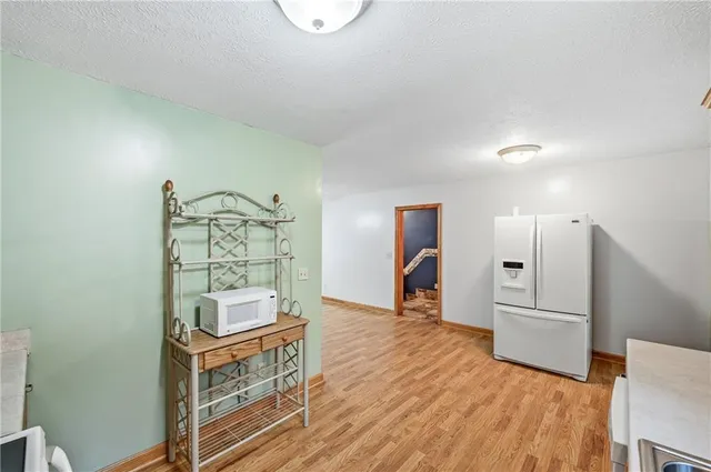 a kitchen with granite countertop a stove a sink and a refrigerator