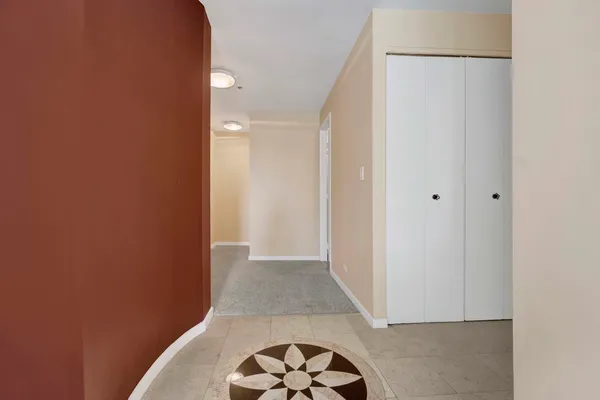 a view of hallway with a door and a rug