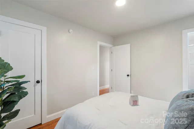 a bedroom with a sink and wooden floor