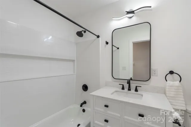 a bathroom with a tub sink and mirror