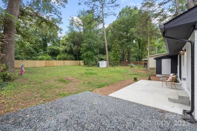 a view of a backyard with a garden and trees