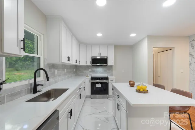 a kitchen with a sink a stove top oven and refrigerator