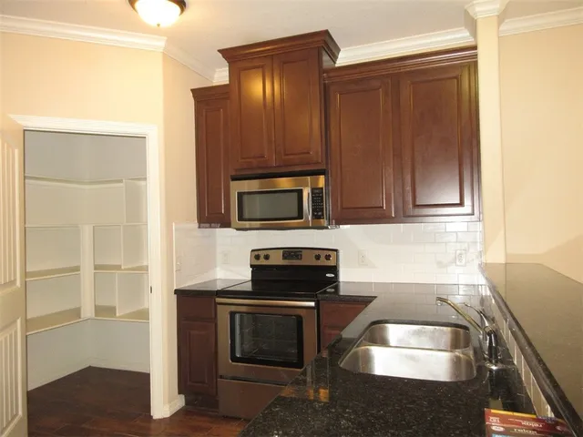 a kitchen with granite countertop cabinets and steel stainless steel appliances