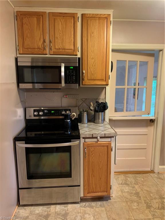 4680 Seward Road Pfafftown, NC 27040 - Photo 11 of 22 KITCHEN WITH STAINLESS STEEL APPLIANCES LOOKING INTO SUNROOM