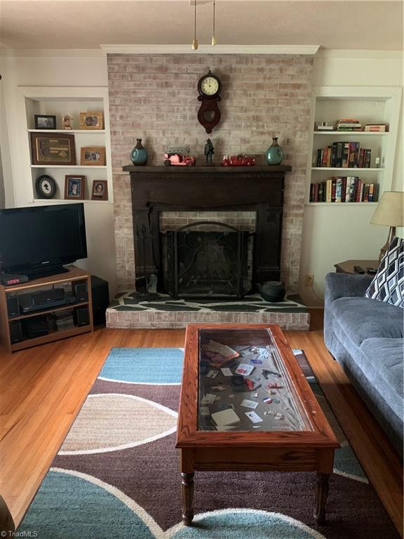 4680 Seward Road Pfafftown, NC 27040 - Photo 8 of 22 LIVING ROOM WITH HARD WOODS AND WOOD BURNING FIRE PLACE WITH BUILT INS