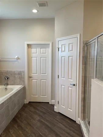 a bathroom with a tub shower and sink