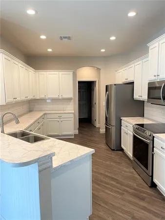 a kitchen with stainless steel appliances granite countertop a refrigerator and a sink