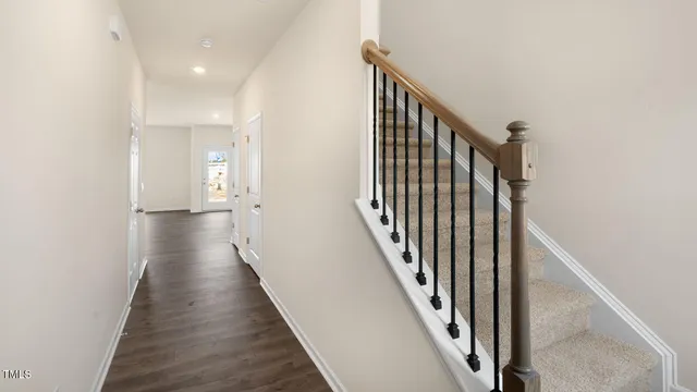 a view of a hallway with wooden floor and staircase