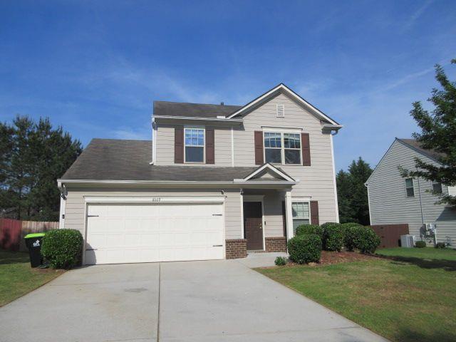 a front view of a house with yard and garage