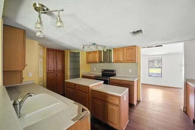 a kitchen that has a sink a stove and chairs