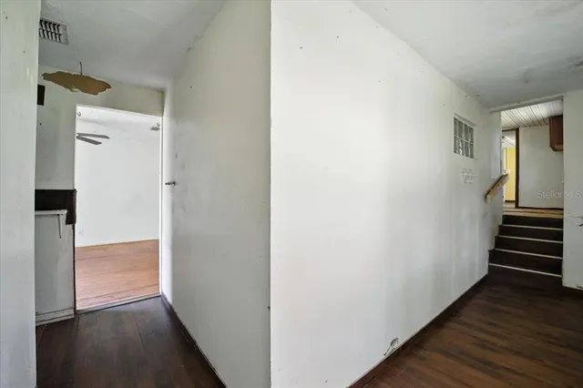 a view of a hallway with wooden floor and entryway