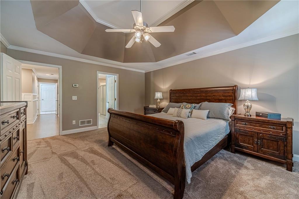4415 Locklin Road Monroe, GA 30655 - Photo 25 of 79 a spacious bedroom with a bed and a chandelier