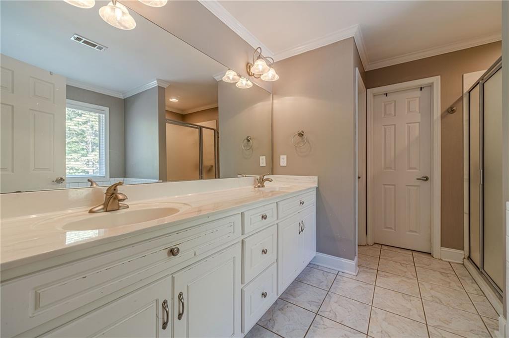 4415 Locklin Road Monroe, GA 30655 - Photo 27 of 79 a spacious bathroom with a double vanity sink a large mirror and a shower