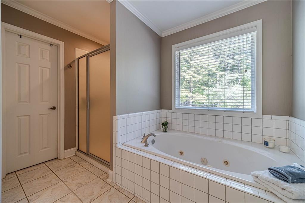 4415 Locklin Road Monroe, GA 30655 - Photo 28 of 79 a bathroom with a bathtub and a shower