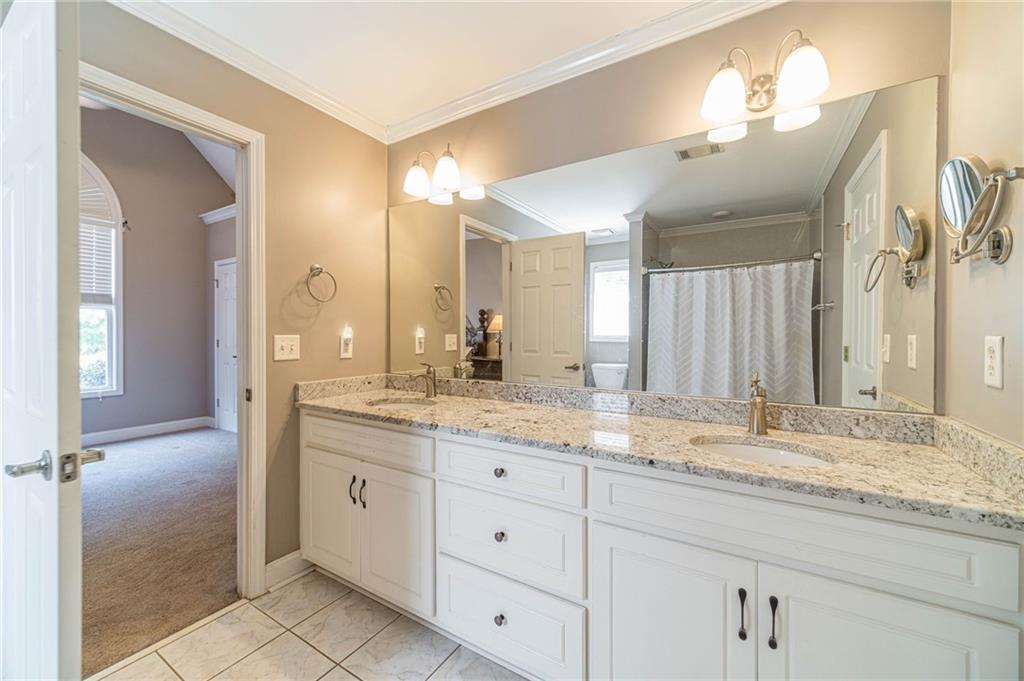 4415 Locklin Road Monroe, GA 30655 - Photo 34 of 79 a bathroom with a granite countertop sink and a mirror