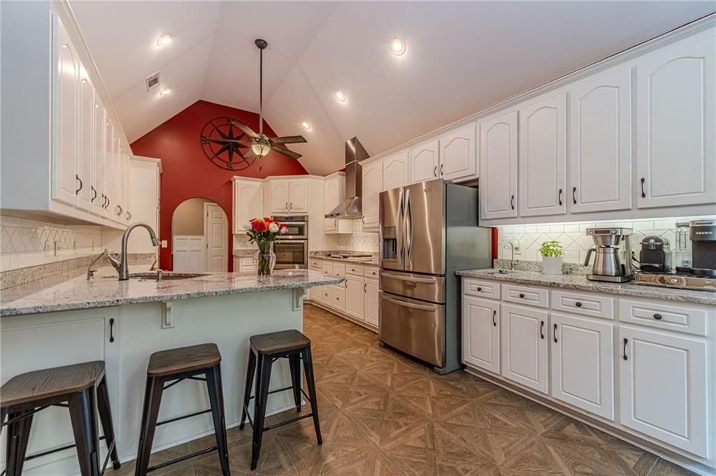 4415 Locklin Road Monroe, GA 30655 - Photo 4 of 79 a kitchen with stainless steel appliances granite countertop a sink a stove a refrigerator and island with wooden cabinets