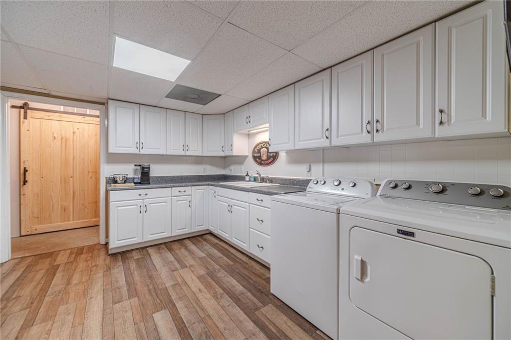 4415 Locklin Road Monroe, GA 30655 - Photo 47 of 79 a kitchen with cabinets appliances a sink and dishwasher with wooden floor