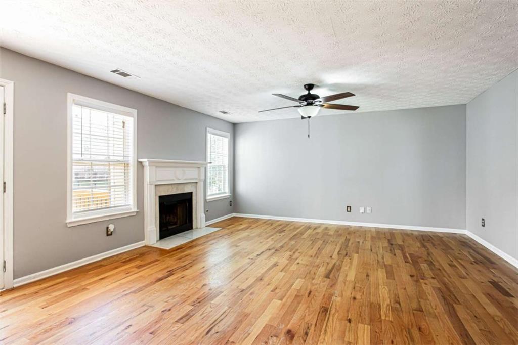 3721 Bogan Mill Road Northeast Buford, GA 30519 - Photo 10 of 58 wooden floor in an empty room with a fireplace and a window