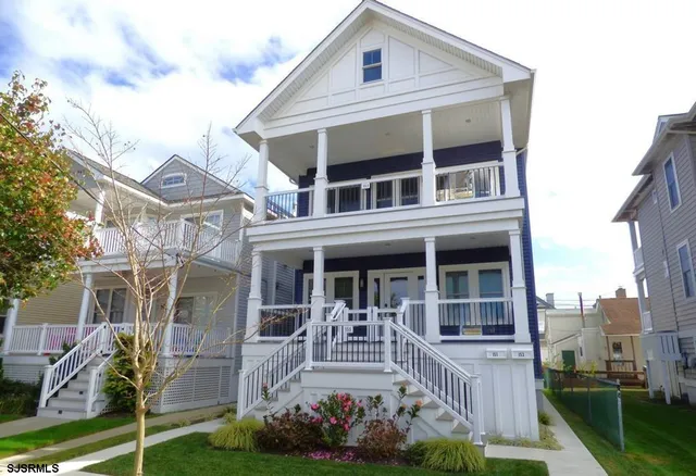 a view of a white building among the yard and large windows