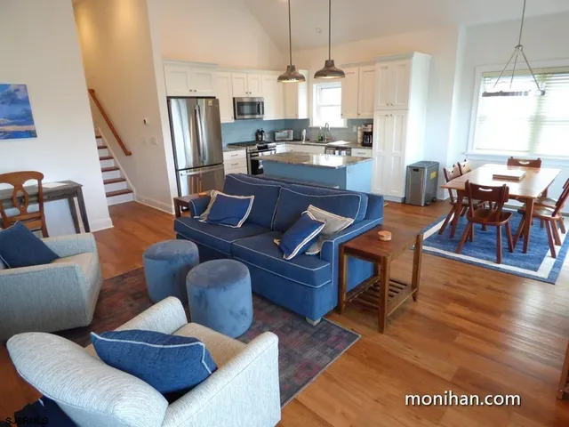 a living room with furniture wooden floor and dining table