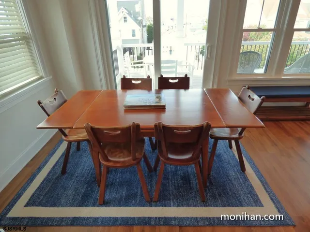 a dining room with furniture and wooden floor