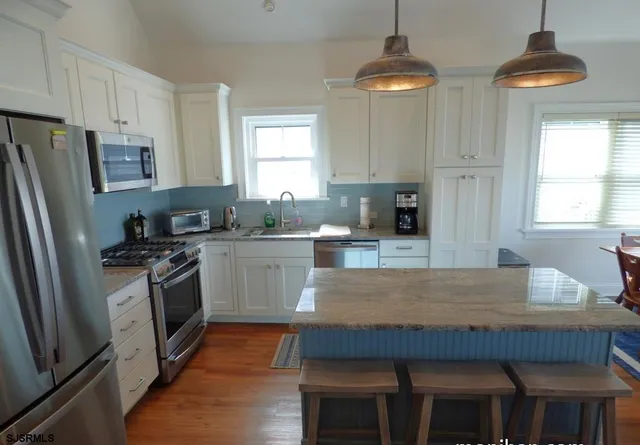 a kitchen with stainless steel appliances granite countertop a stove refrigerator sink and cabinets