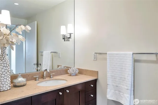 a bathroom with a granite countertop sink a large mirror and vanity