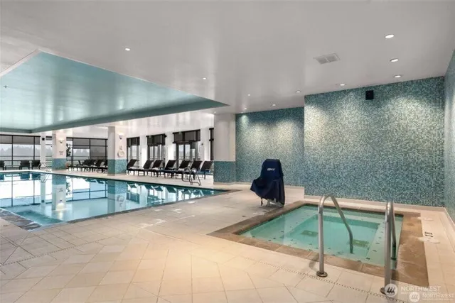 a indoor swimming pool with table and chairs